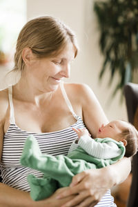 Mother carrying son at home