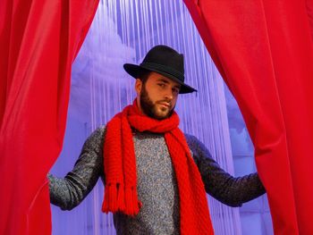 Man looking away while standing in red umbrella