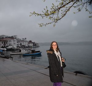 Portrait of woman standing in boat against sky