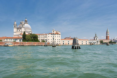 Buildings in sea against sky