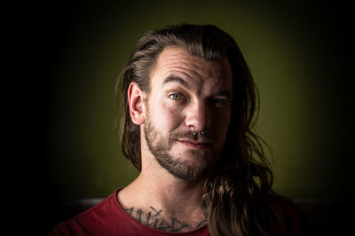 Portrait of young man against black background