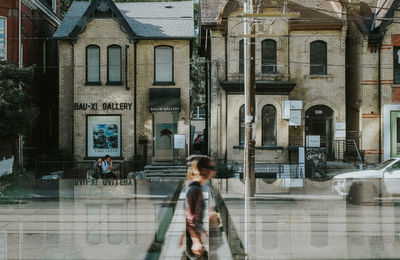 Full length of woman walking on street against buildings in city