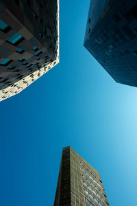 Low angle view of modern buildings against clear blue sky