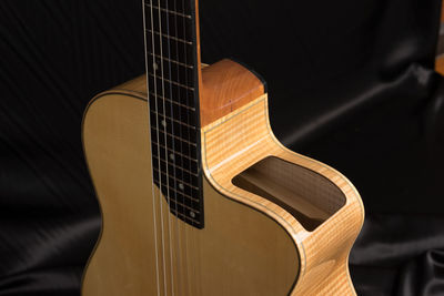 High angle view of acoustic guitar on bed