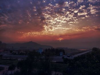 High angle view of town against cloudy sky during sunset