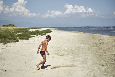 Full length of shirtless man on beach