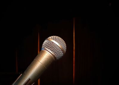 Low angle view of electric fan against black background