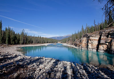 Scenic view of lake and mountains against blue sky