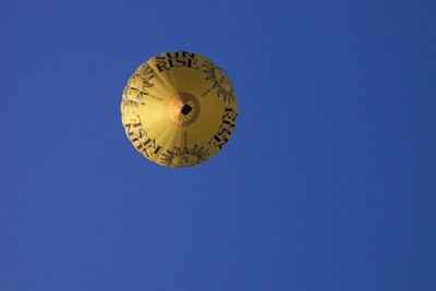 Low angle view of clock against clear blue sky