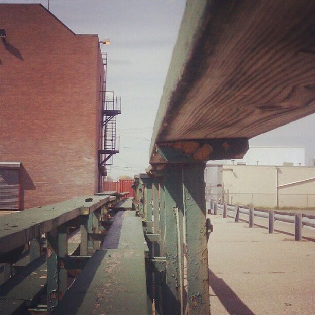 built structure, architecture, building exterior, sky, house, railing, wood - material, no people, sunlight, residential structure, outdoors, day, wall - building feature, building, residential building, roof, transportation, shadow, the way forward, wall