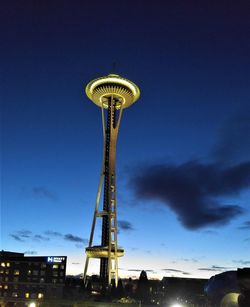 Low angle view of illuminated tower against sky at dusk