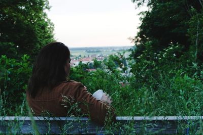 Rear view of woman looking at plants