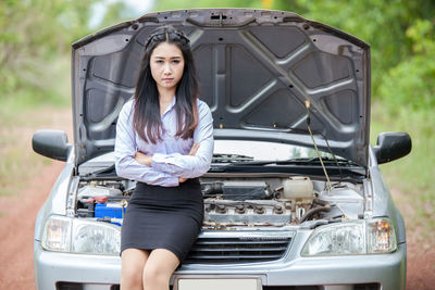 Portrait of businesswoman standing by car