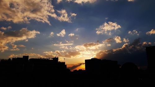 Low angle view of silhouette buildings against sky at sunset