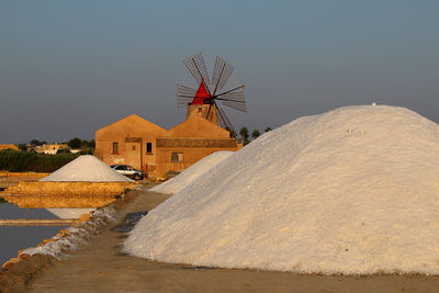 Traditional windmill on mountain against sky