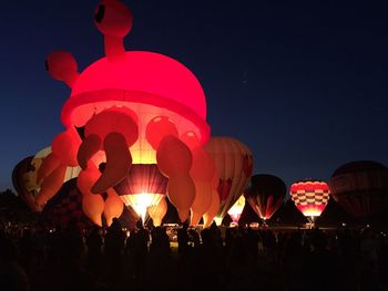 Crowd in traditional clothing against clear sky at night