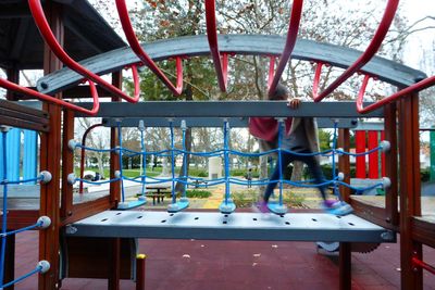 Blur image of child walking on jungle gym in park