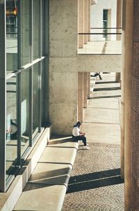 Shadow of man sitting on staircase of building