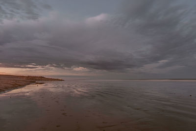 Scenic view of beach against sky during sunset