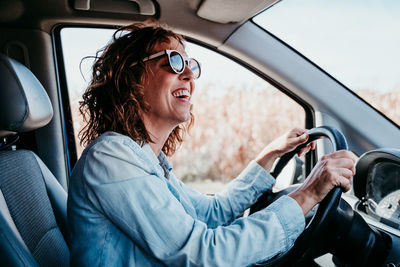 Side view of woman sitting driving car