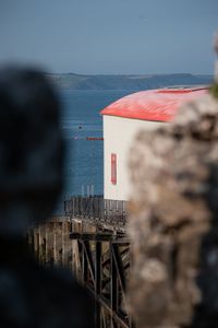 Rear view of man on bridge over sea against sky