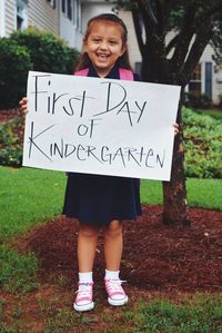 Portrait of smiling girl holding text on placard