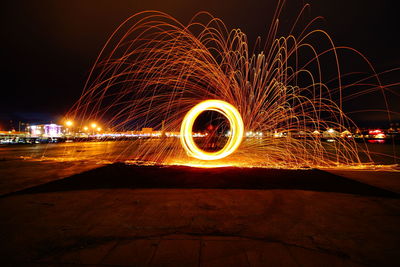 Light trails in city against sky at night