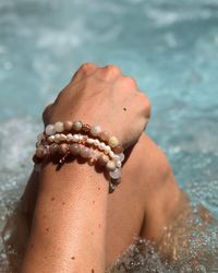 Cropped image of woman wearing bracelet in swimming pool