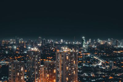 High angle view of illuminated buildings against sky at night