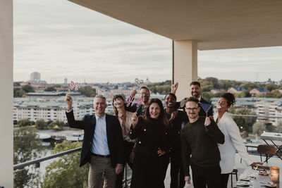 Portrait of business people using props during office party