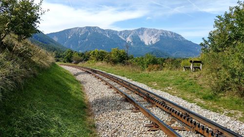 View of railroad track by mountain against sky