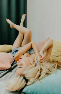 Rear view of woman lying on bed at home