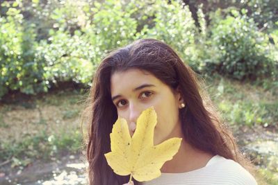 Portrait of a young woman holding plant