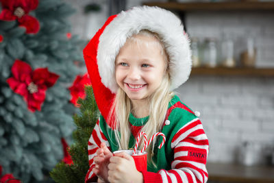 Cute little child girl eating sweet cookies and drinking hot cocoa