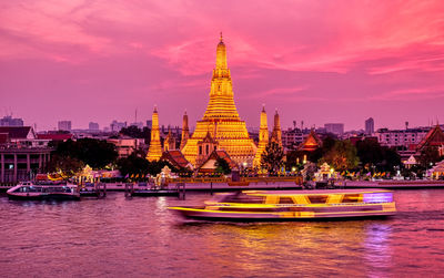 Temple by building against sky during sunset