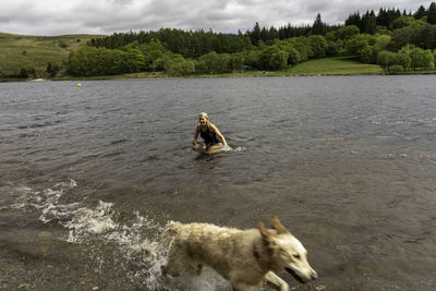 Woman and dog enjoying in lake