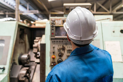 Rear view of man working in factory