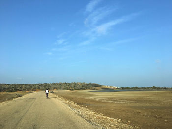 Rear view of person riding motorcycle on road