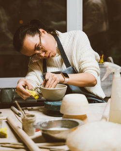 Woman making clay pot