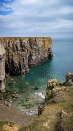Scenic view of rocks in sea against sky