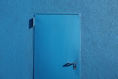 Closed blue door on wall