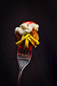 Close-up of ice cream cone on table against black background