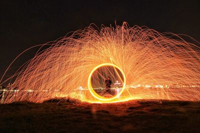 Man making wire wools against clear sky at night