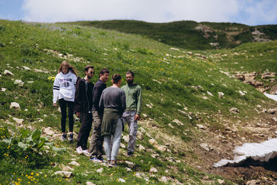 Rear view of people walking on landscape