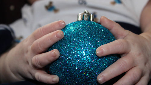 Midsection of baby holding christmas bauble