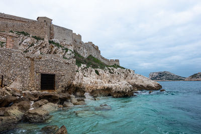 Buildings by sea against sky