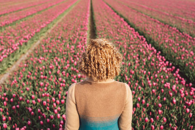 Rear view of woman walking on field