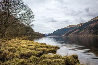 Scenic view of lake against cloudy sky