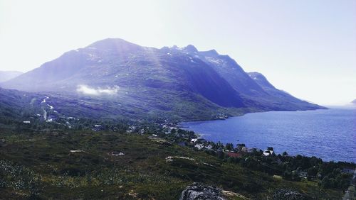 Scenic view of sea and mountains against clear sky