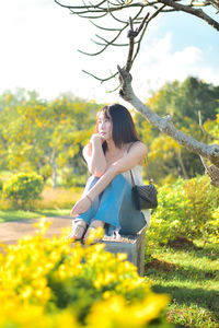 Side view of woman sitting on field